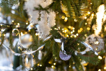 Decorated Christmas tree with Christmas balls, tinsel and warm yellow lights. Festive atmosphere.
