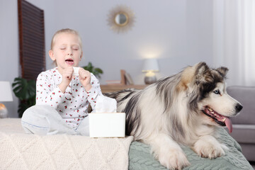 Girl suffering from allergy with her dog on bed at home