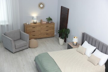 Bed, armchair and chest of drawers in room, above view