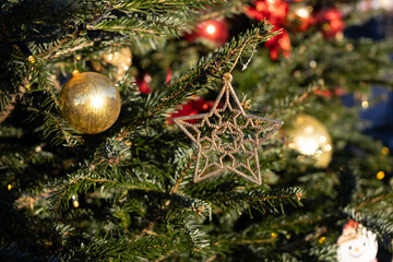 Decorated Christmas tree with Christmas balls, tinsel and warm yellow lights. Festive atmosphere.