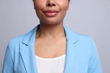 Young woman with healthy skin on light grey background, closeup