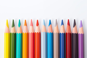 Fototapeta premium Multicolored pencils arranged in a straight line on a white background.