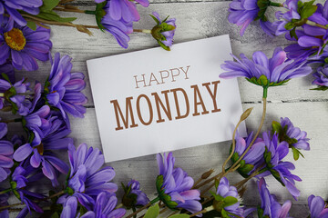 Happy Monday text with flowers decoration on wooden background