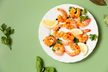 Cooking process of cooking shrimps with lemon in a plate isolated on green