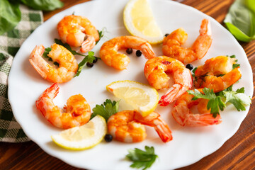Fried juicy shrimps in a plate on a wooden