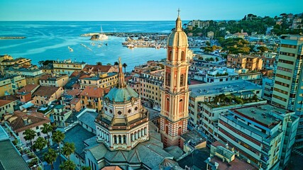 Aerial panorama of Rapallo basilica bell tower framed by yacht-filled harbor and Ligurian Sea, Italian Riviera coast, Italy	