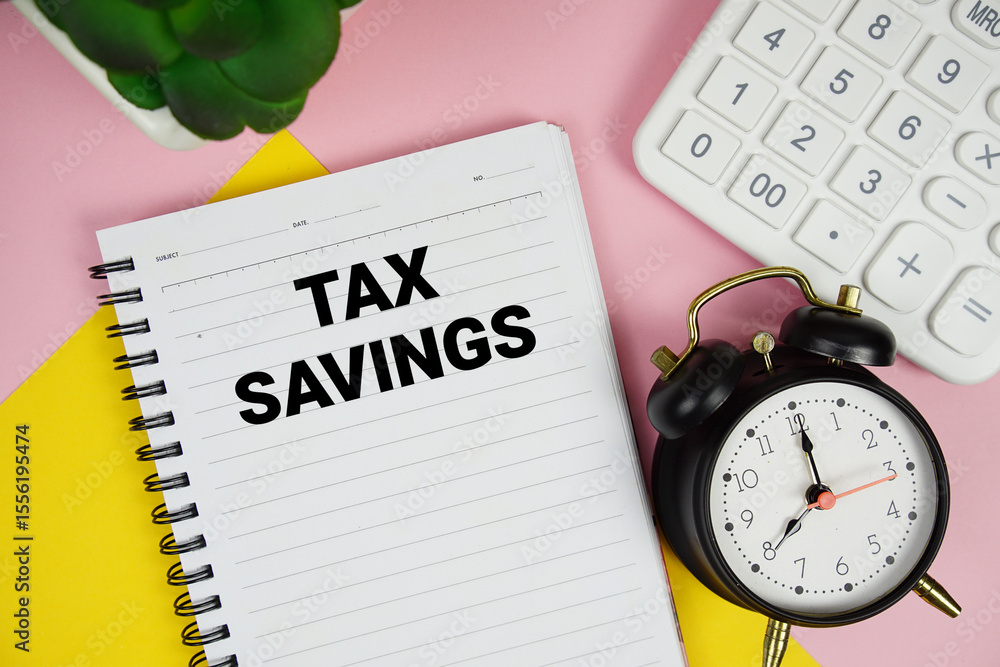 Poster tax savings text written on notepad with calculator and alarm clock on pink background