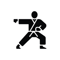 Karate fighter in black gi performing a punch and defensive stance