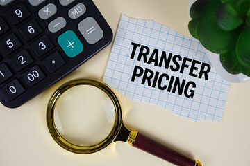 Transfer Pricing text with magnifying glass anc calculator on yellow background
