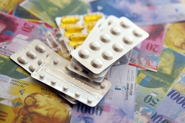 Swiss franc banknotes and medicine pills. The current francs money bills and drugs lies on table