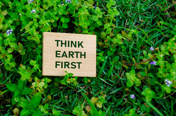 Think Earth First text on wooden block, representing a mindful reminder to always put the planet...