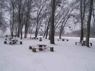Tables and benches. A place to relax in nature. Deserted in winter. Snow and silence.
