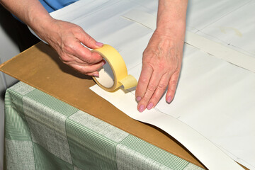 The cutter creates a template, a pattern, from paper on the table.