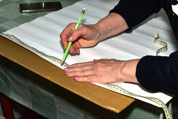 The moment when a cutter creates patterns for sewing clothes. The clothes designer applies markings...