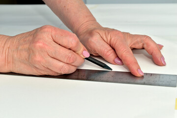 The moment when a cutter creates patterns for sewing clothes. The clothes designer applies markings...