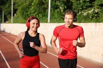 Sporty couple running at stadium. Healthy lifestyle