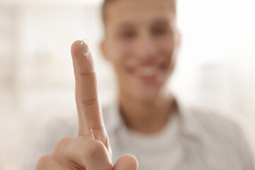 Man with contact lens at home, selective focus