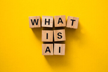 What is ai: wooden cubes spelling artificial intelligence on yellow background
