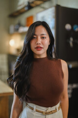 Confident young Asian businesswoman standing in a modern office, exuding professionalism and...