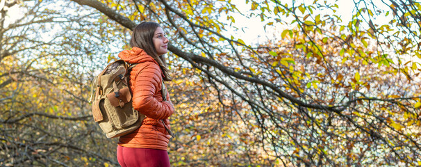 Autumn panoramic view of woman contemplating forest