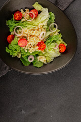 Pasta salad green leaf lettuce, tomato, pasta, onion fresh delicious gourmet food background on the table rustic food top view copy space keto and paleo diet vegan and vegetarian food
