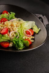 Pasta salad green leaf lettuce, tomato, pasta, onion fresh delicious gourmet food background on the table rustic food top view copy space keto and paleo diet vegan and vegetarian food