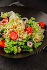 Pasta salad green leaf lettuce, tomato, pasta, onion fresh delicious gourmet food background on the table rustic food top view copy space keto and paleo diet vegan and vegetarian food