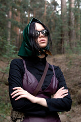 Elegant Woman in Green Headscarf and Leather Dress Posing in Forest Setting