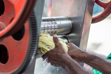 A man is making sugarcane juice with a machine.