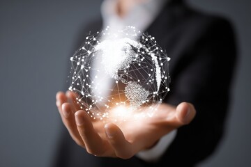 Hand holding glowing networked globe over dark gray backdrop, person in suit blurry