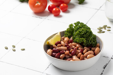  Mixed salad of canned beans with lemon and greens on a plate for healthy eating. Plant protein
