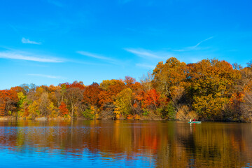 Seasonal fall landscape. Park boat in autumn pond. Scenic fall. Central park in autumn. Autumn landscape. Boat in pond. Fall nature landscape. Autumn nature in Central park. Fall boat rides