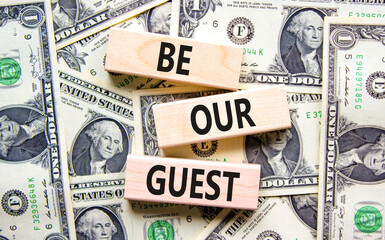 Be our guest symbol. Concept words Be our guest on beautiful wooden blocks. Dollar bills. Beautiful...