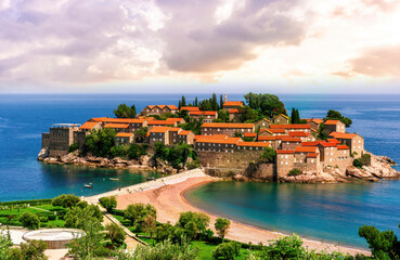picturesque seascape of beautiful isle Sveti Stefan near Budva Montenegro. Scenic orange buildings...