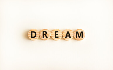 Dream symbol. Concept word Dream on beautiful wooden circles. Beautiful white table white background. Business lifestyle dream concept. Copy space.