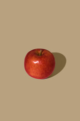 Apple on a brown background. Warm light. Minimalistic food concept. © Ivana