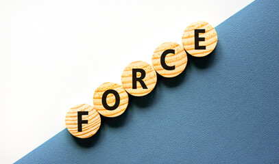 Force symbol. Concept word Force on beautiful wooden circles. Beautiful white and blue background....
