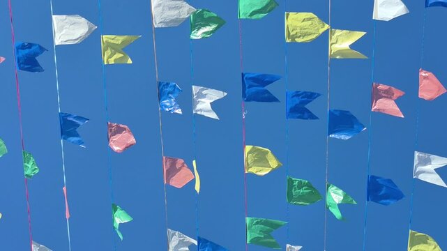 Bandeirinhas decorativas se movendo com o vento em dia claro e ensolarado