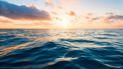 Obraz premium Ocean waters ripple gently under a vibrant sunset sky, bathed in soft pastel hues of pink, orange, and blue.