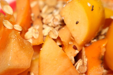 persimmon with granola. Persimmon and granola. Ready to eat persimmon. Persimmon with selective focus. 