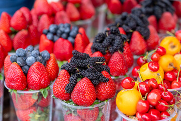 Assorted containers of berries for sale at a market. Fruits