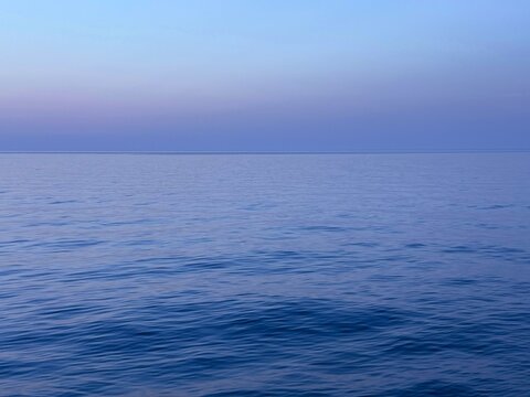 Calm blue sea and dusk sky at evening.