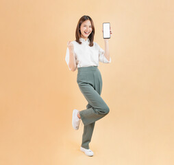 Confident Asian woman holding big smartphone mockup of blank screen and smiling on beige color background.