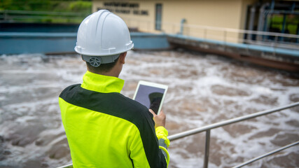 A wastewater treatment engineer is checking the operation of a water treatment system