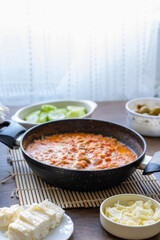 Turkish style breakfast: menemen eggs, chechil cheese, white cheese, kashar cheese and Turkish tea	