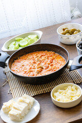 Turkish style breakfast: menemen eggs, chechil cheese, white cheese, kashar cheese and Turkish tea	