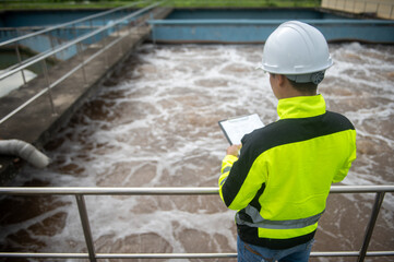 A wastewater treatment engineer is checking the operation of a water treatment system