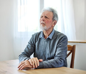 Portrait of a serious sad mature old man at home