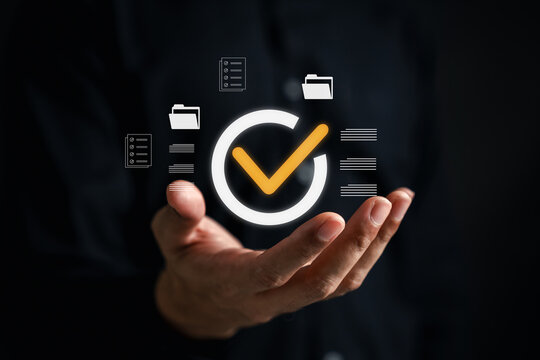 Hand using digital to review documents with check mark icons - Powered by Adobe