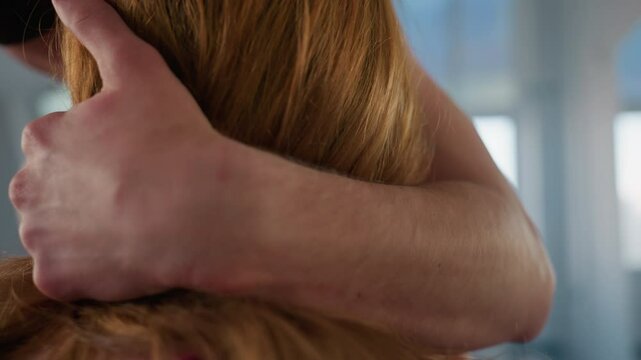 close up of bare chested man dancing closely behind seated woman, arms wrapped around her shoulders and chest pressed to her back in soft bright studio with mirrored walls and window light